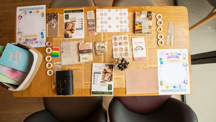 Handwritten journal pages beside plants and coffee